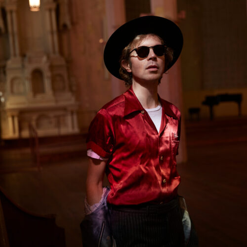 Billede af Beck iført rød skjorte, solbriller og hat ved Heartland Festival