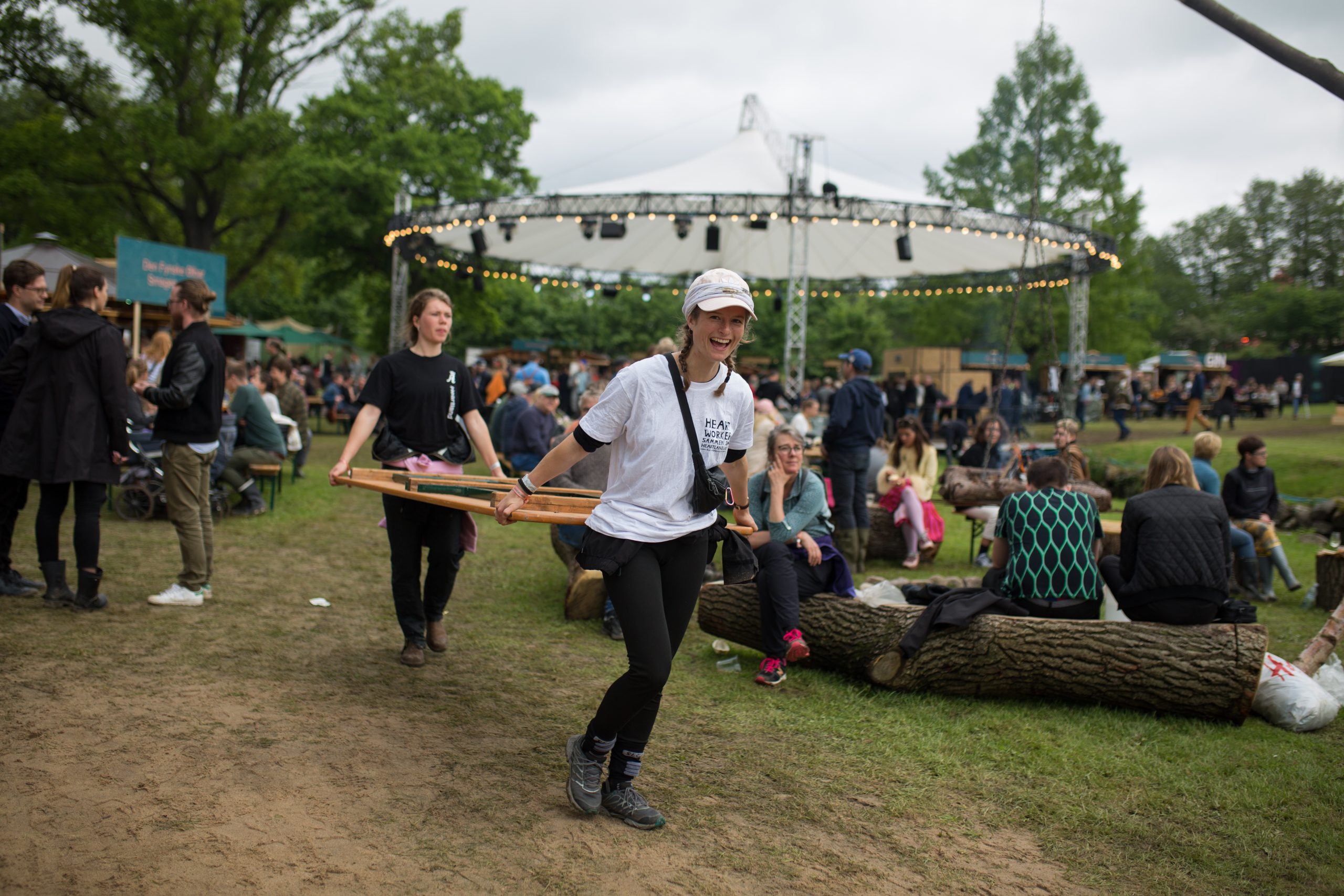 Mennesker hygger sig ved Heartland Festival og bærer et træbord