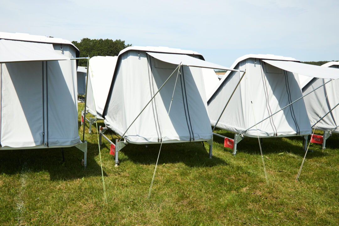 Tre Tent House´s på række på en grøn græsplæne