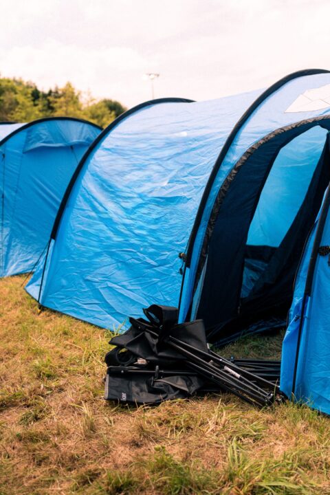 Et opslået telt med campingstole foran