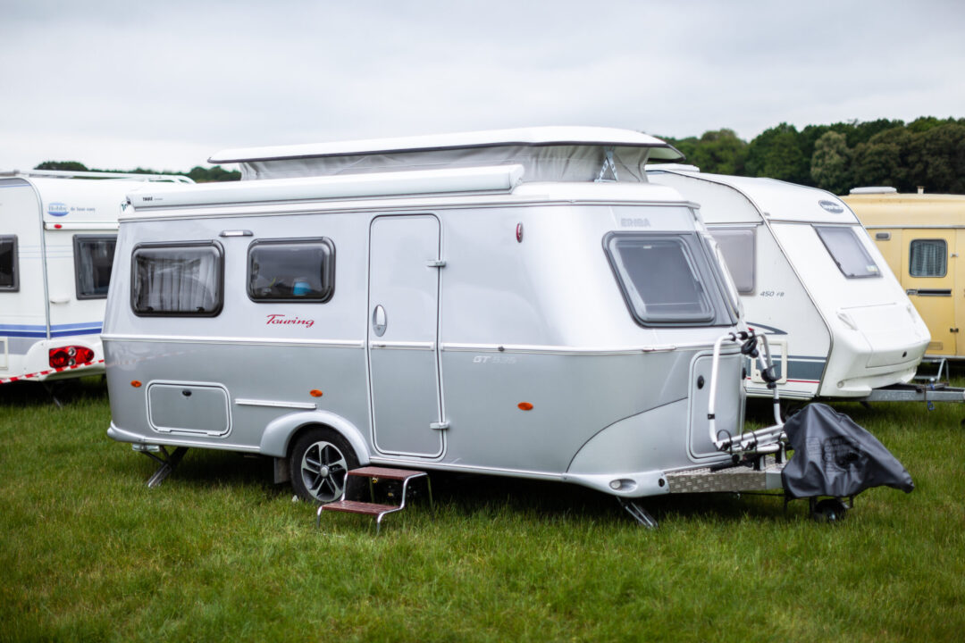 En række campingvogne, der står på en grøn græsplane i caravanområdet.