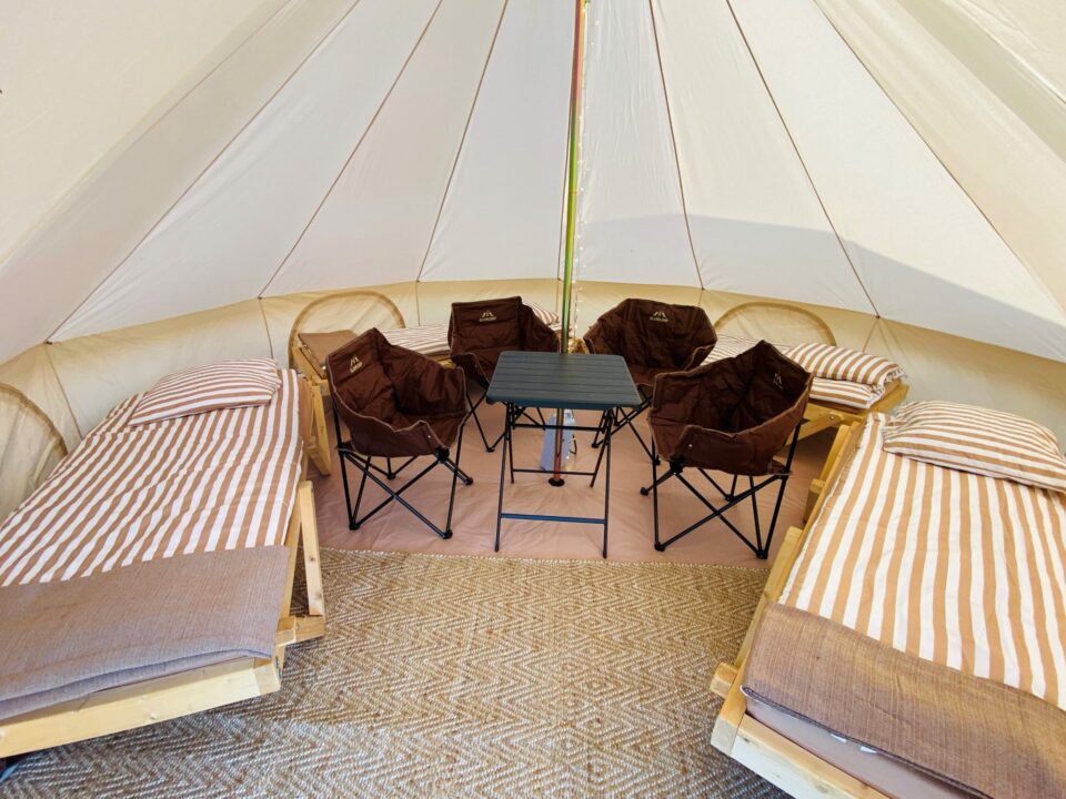 Billede indeni glampingteltet til 4 personer. Her er 4 dejlige senge, 4 campingstole samt et bord.