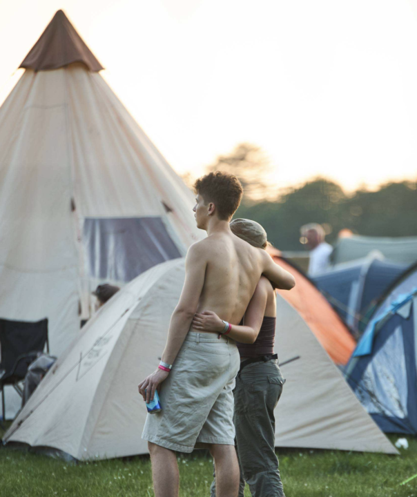 Et par der holder om hinanden foran campingområdet