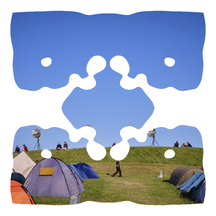 Campingområdet med blå himmel og grønt græs gemt bag en sanselig ramme