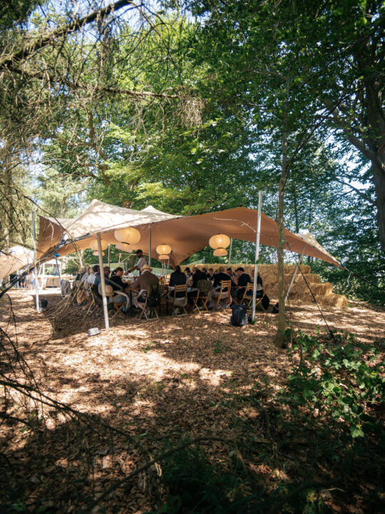 En overdækkende restaurantoplevelse i en skov med smukke rispapirlamper og halmballer