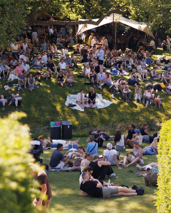 billede af festivalgæster der ligger og sidder på græsplæne